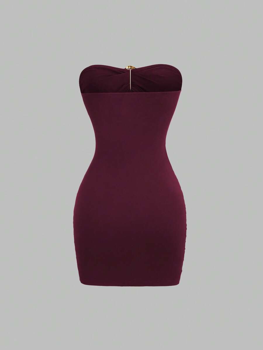 Women's black strapless bodycon mini dress featuring ruched detailing, cut-out design with ring accent, mid-waist pencil hem, and slim fit knitted stretch fabric.