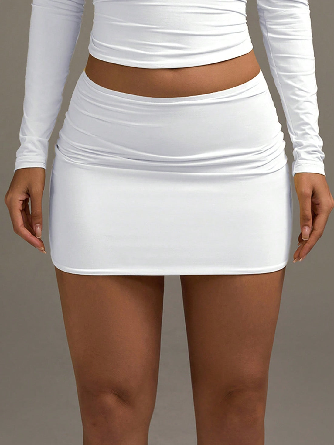 White low waist ruched bodycon mini skirt made of high stretch knitted fabric.