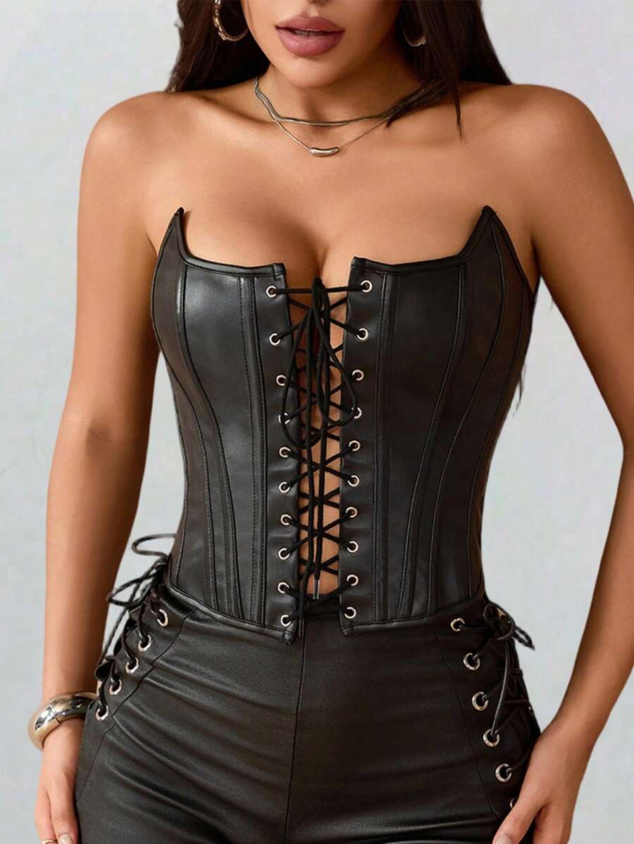 Black PU leather strapless bustier corset crop top featuring boned structure, lace-up grommet eyelets, and an asymmetrical hem on a women model.