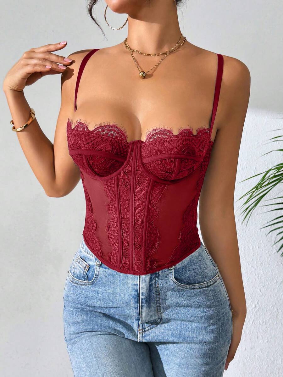 Front view of a black seamless lace camisole crop top featuring delicate spaghetti straps and intricate contrast lace detailing.