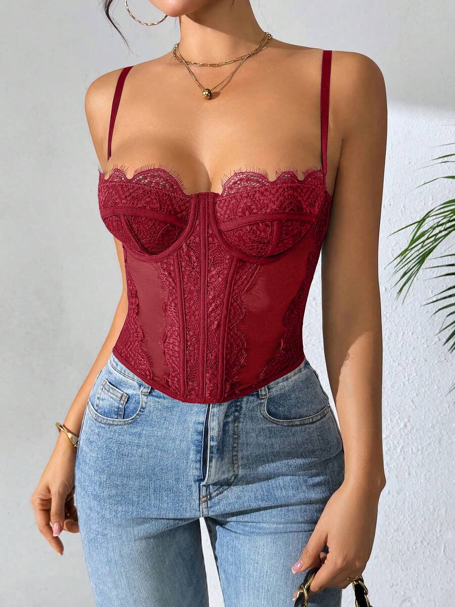 Front view of a black seamless lace camisole crop top featuring delicate spaghetti straps and intricate contrast lace detailing.