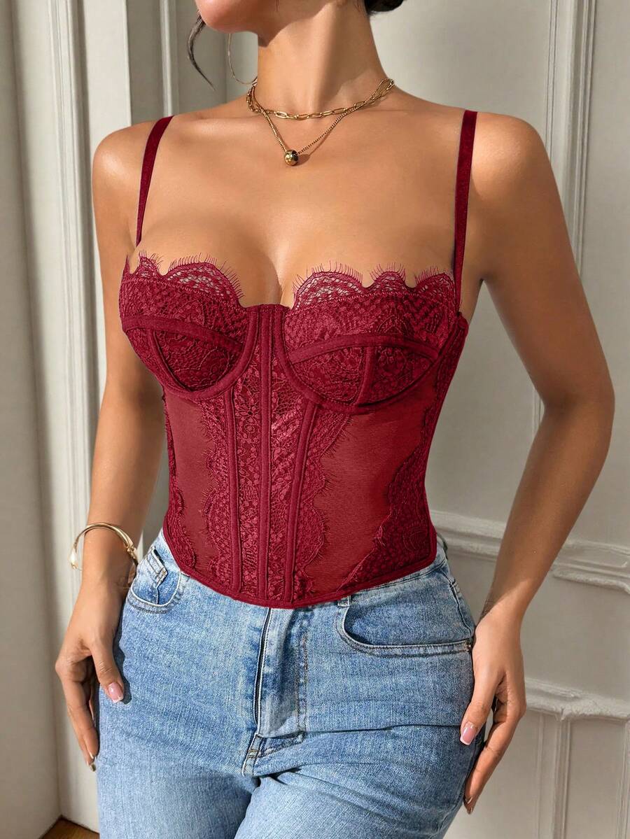 Front view of a black seamless lace camisole crop top featuring delicate spaghetti straps and intricate contrast lace detailing.