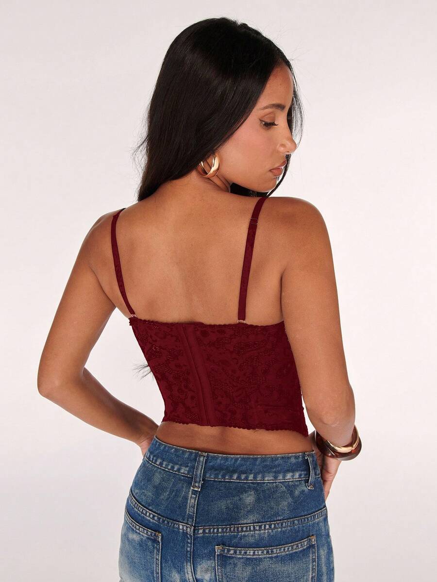 Black women’s lace cami top with spaghetti straps, contrast lace details, and an asymmetrical hem, styled as a slim-fit lined casual top.