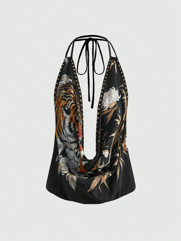 Front view of women's black halter tank top featuring graphic print, rhinestone embellishments, and a backless tie-back design.