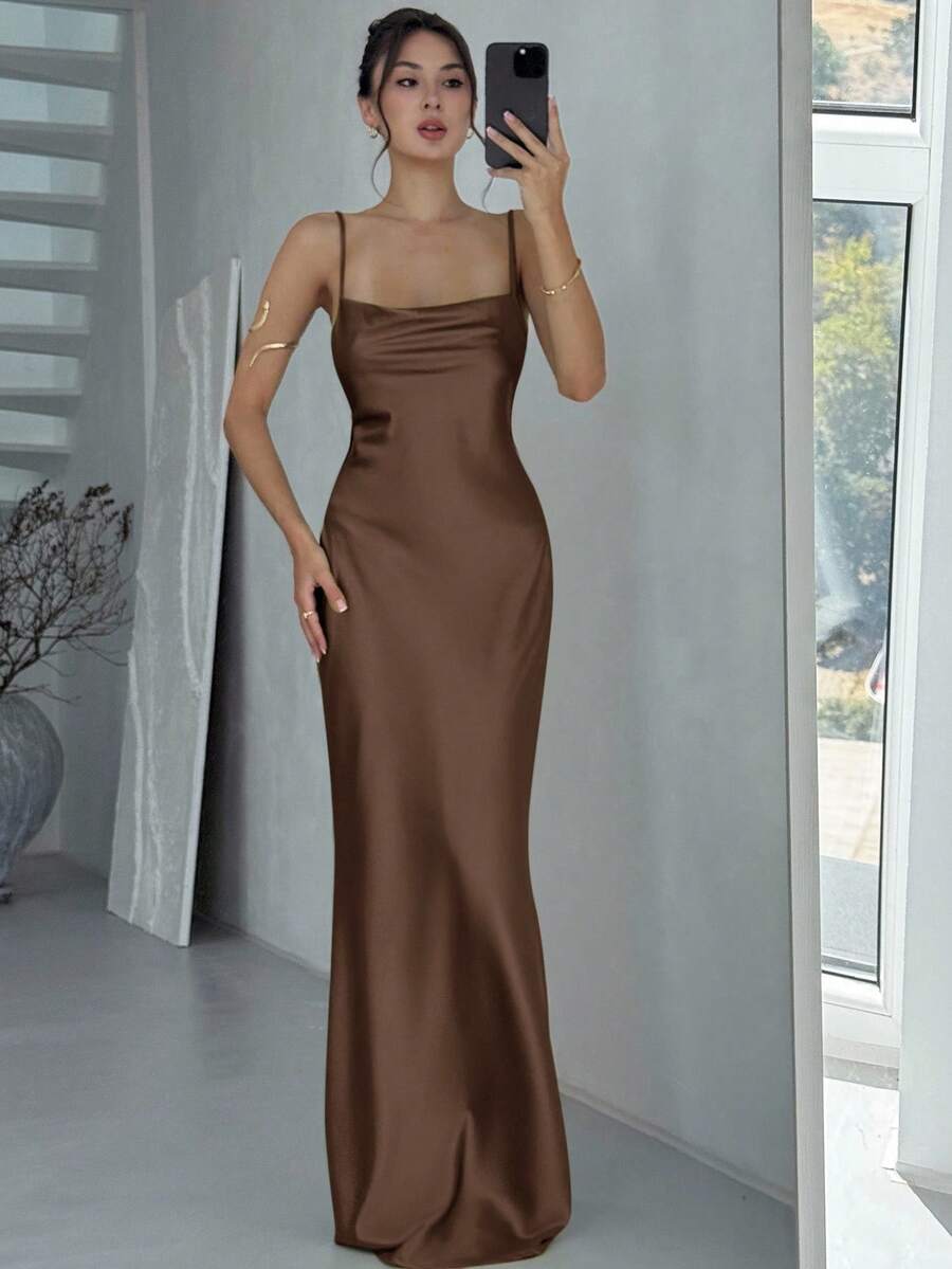Beige satin backless maxi dress featuring criss-cross spaghetti straps and a mermaid hemline.