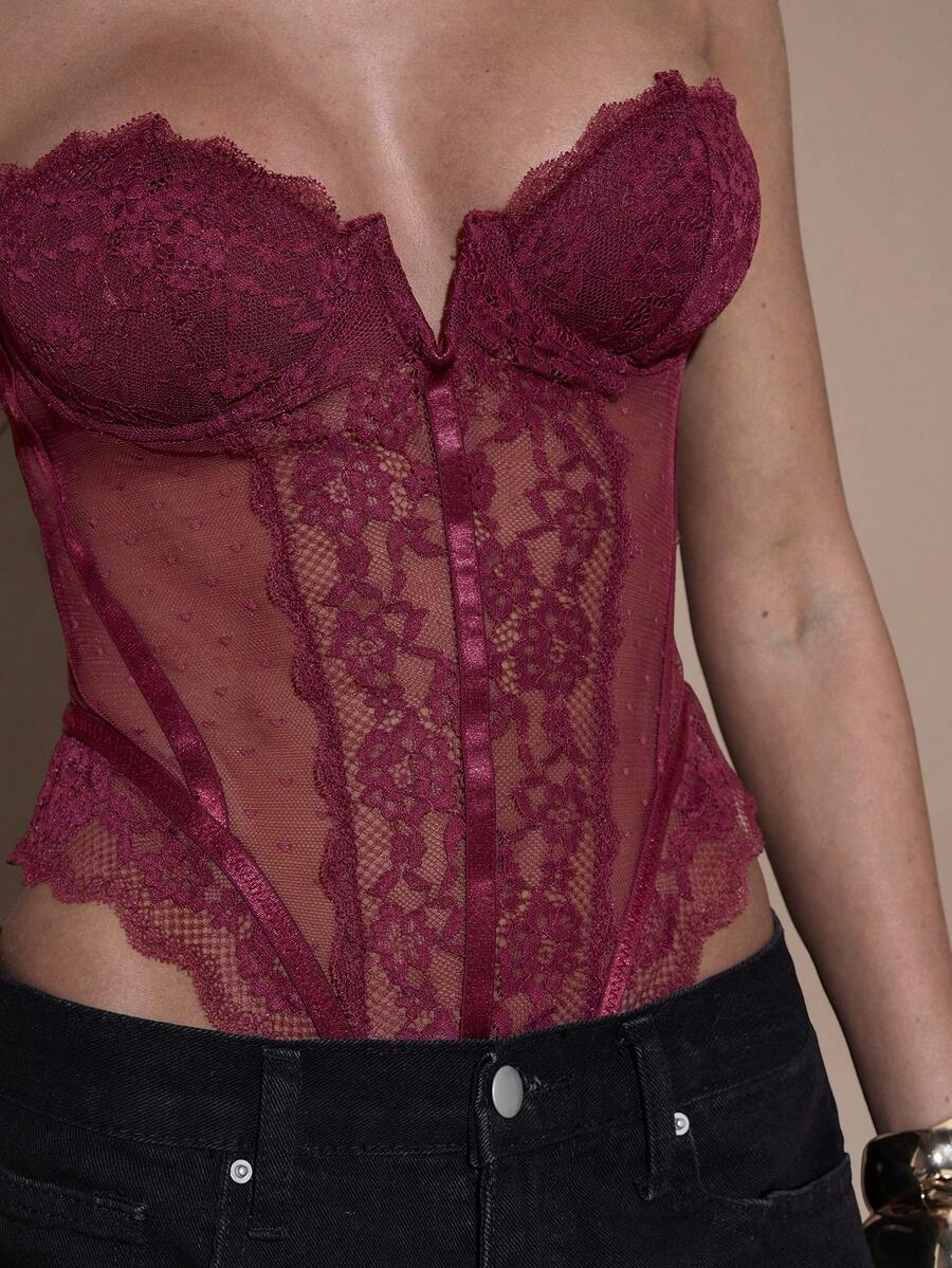 Women's slim fit contrast lace cami bodysuit featuring thin spaghetti straps and asymmetrical detailing.