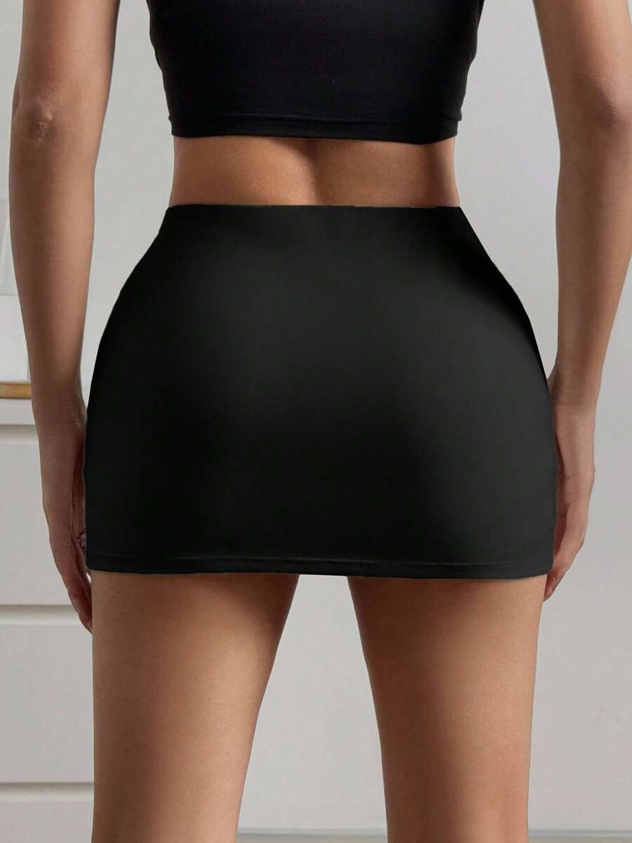 Women's black casual low rise bodycon mini skort with built-in shorts in knitted plain stretch fabric.