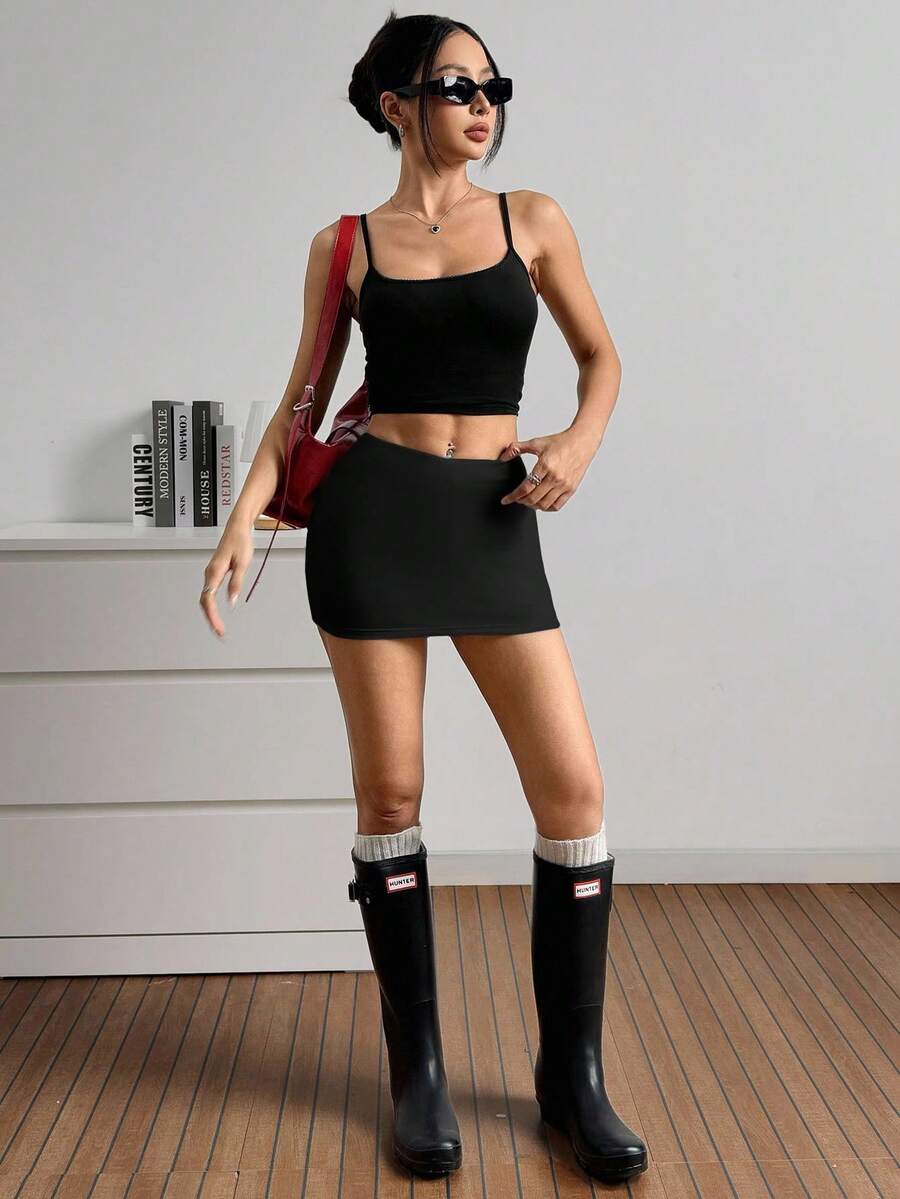 Women's black casual low rise bodycon mini skort with built-in shorts in knitted plain stretch fabric.