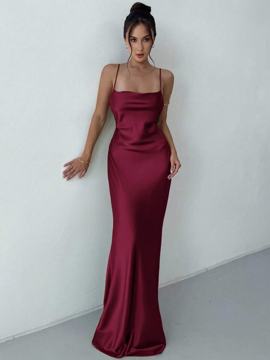 Beige satin backless maxi dress featuring criss-cross spaghetti straps and a mermaid hemline.