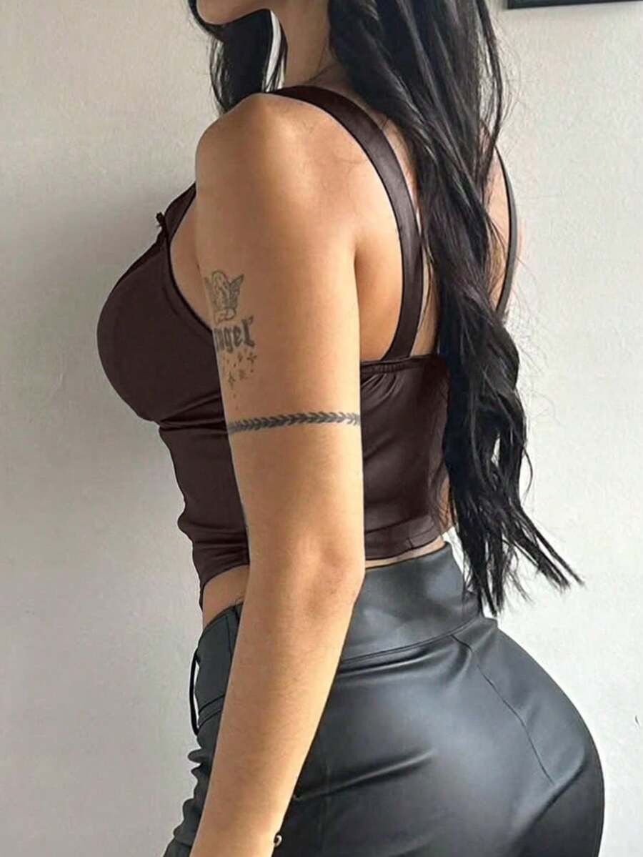 Women's black PU leather fishbone corset crop top featuring a lace-up front with metal eyelets and an asymmetrical hem.
