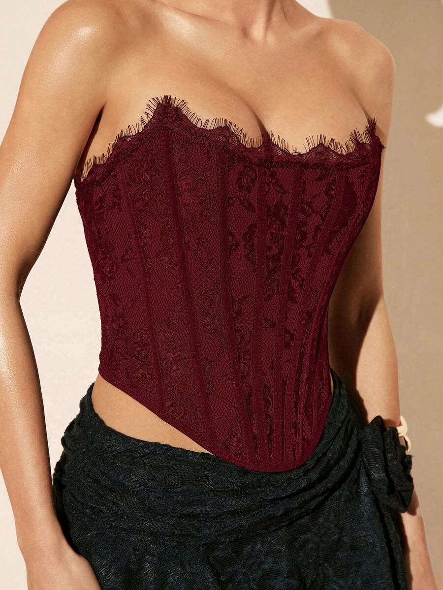 Women's strapless bustier crop top with contrast lace, lace-up detail, and an asymmetric hem in a slim-fit satin finish.