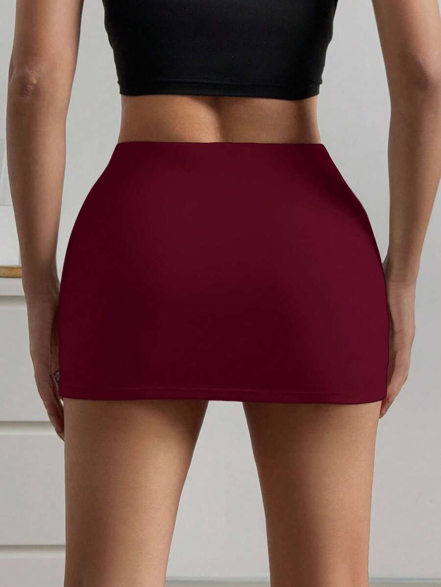Women's black casual low rise bodycon mini skort with built-in shorts in knitted plain stretch fabric.