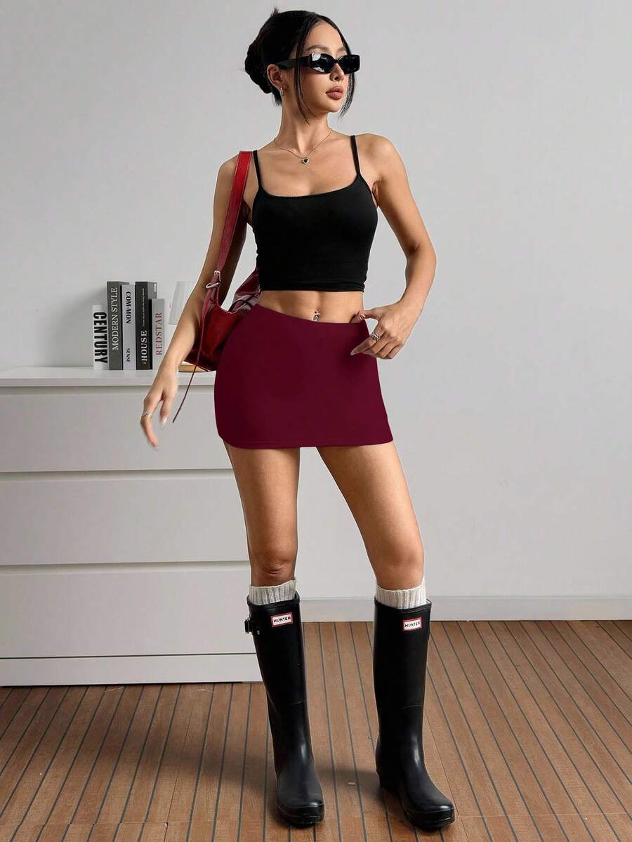 Women's black casual low rise bodycon mini skort with built-in shorts in knitted plain stretch fabric.