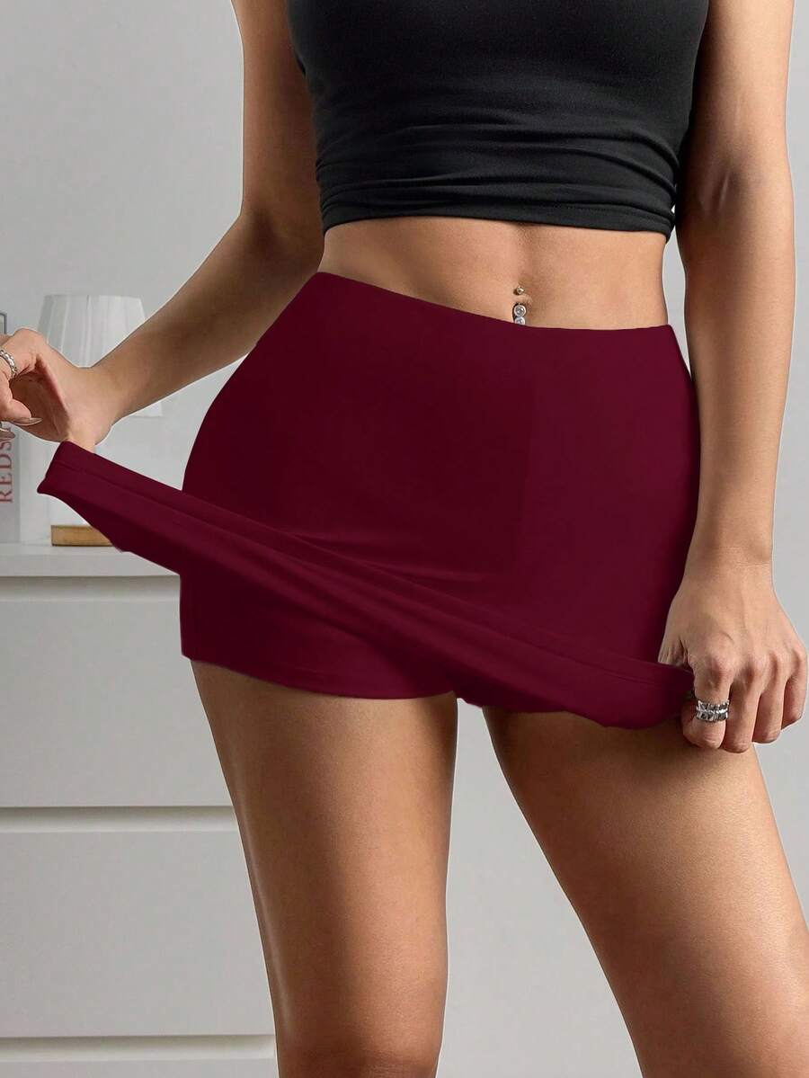 Women's black casual low rise bodycon mini skort with built-in shorts in knitted plain stretch fabric.