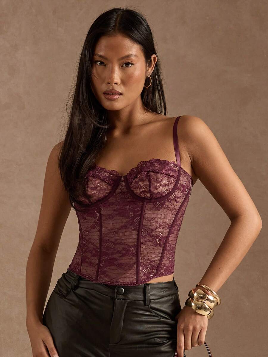 Black women’s lace cami top with spaghetti straps, contrast lace details, and an asymmetrical hem, styled as a slim-fit lined casual top.