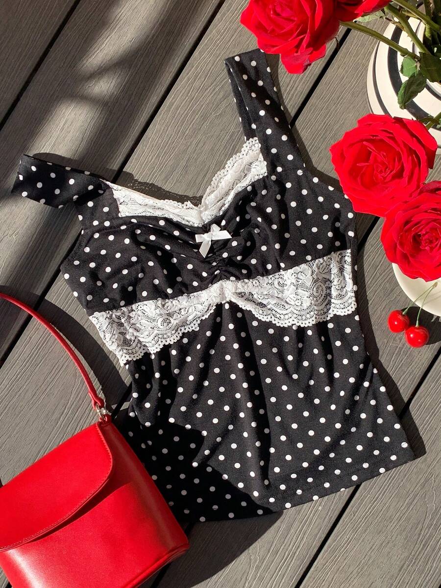 Black and white polka dot knit camisole tank top featuring delicate contrast lace trim, a cute bow accent at the sweetheart neckline, and slender shoulder straps.