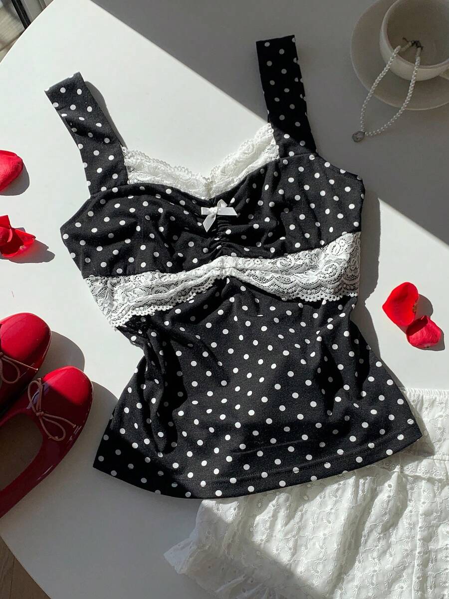 Black and white polka dot knit camisole tank top featuring delicate contrast lace trim, a cute bow accent at the sweetheart neckline, and slender shoulder straps.