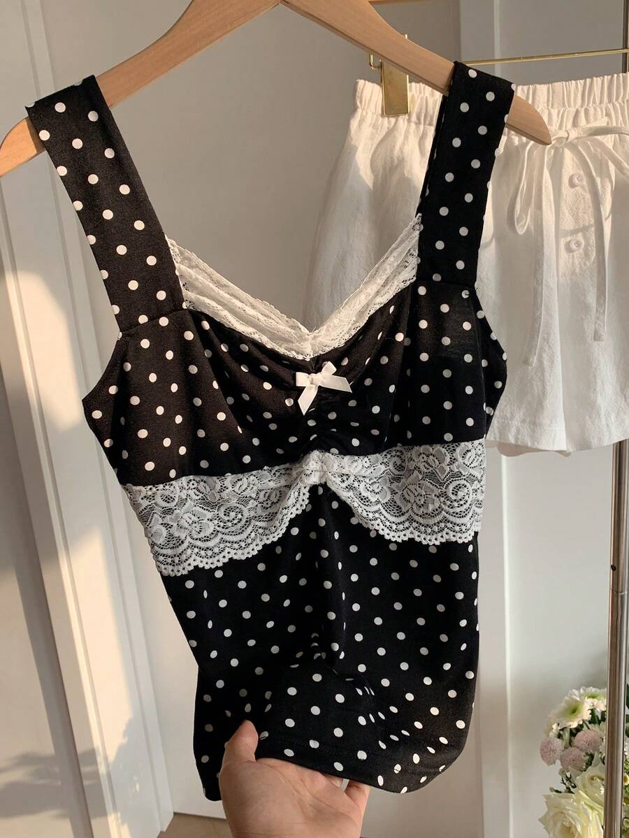 Black and white polka dot knit camisole tank top featuring delicate contrast lace trim, a cute bow accent at the sweetheart neckline, and slender shoulder straps.