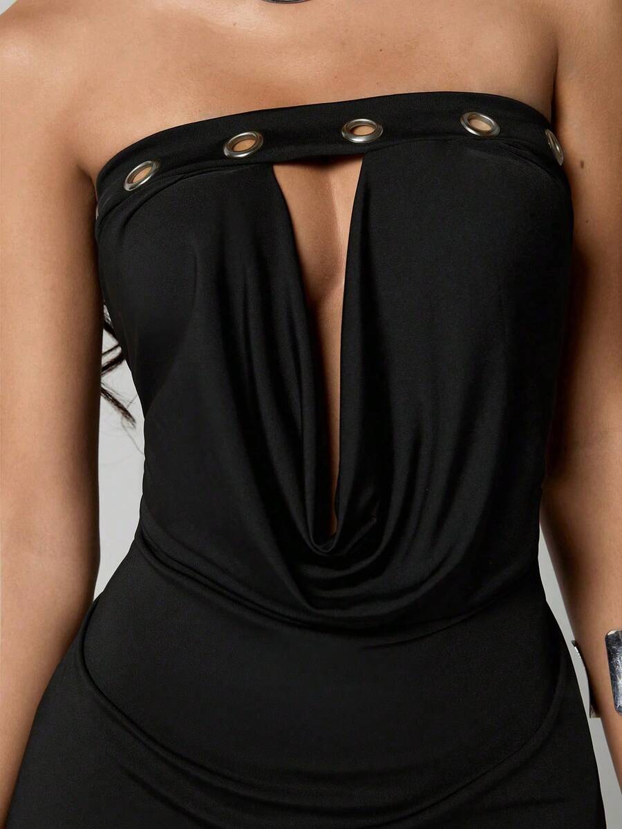 Woman wearing a black strapless bustier bodycon mini dress featuring silver grommet details and ruched hollow-out design.