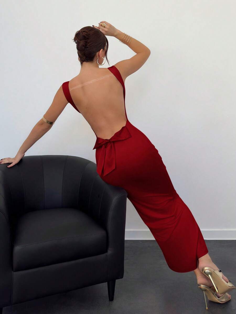 Beige sleeveless backless cami maxi dress for women featuring bow decor, split hem, and slim fit knitted fabric.