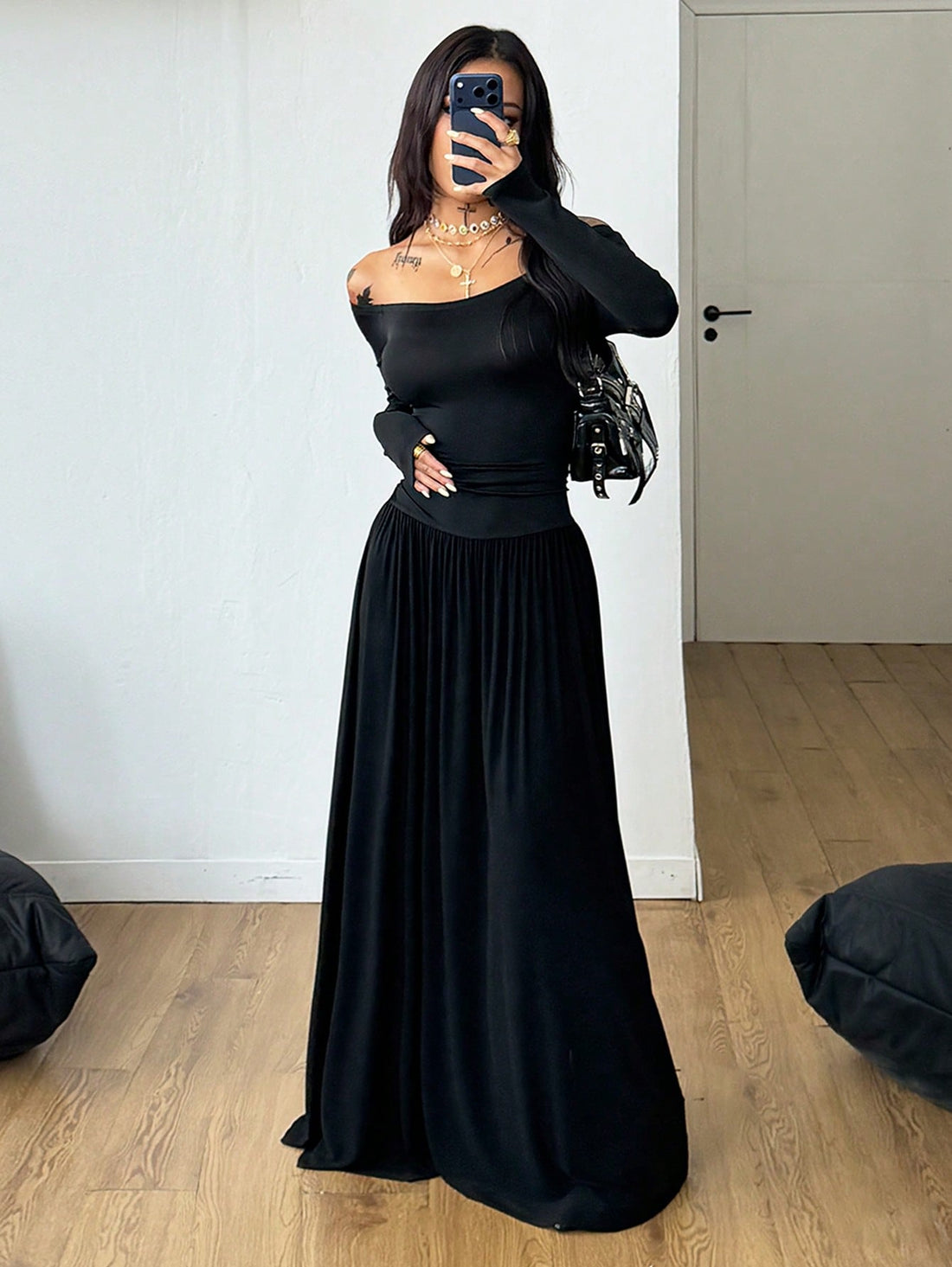 Women wearing a brown off the shoulder maxi dress with asymmetrical ruched cut out details and wrist-length sleeves in a slim fit flared A-line design.