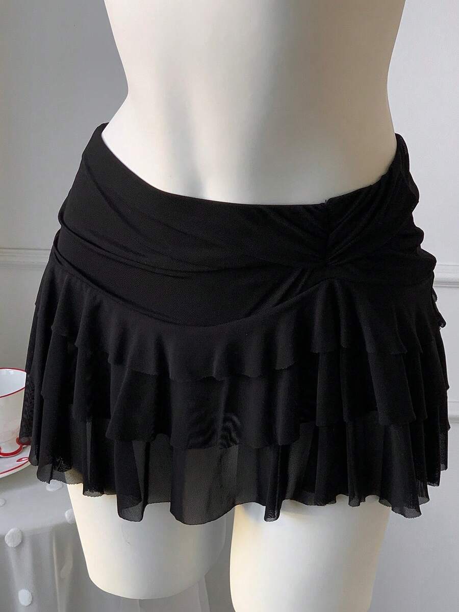 Black tiered ruffle mini cake skirt for women featuring a mid-waist pleated design and layered ruffle hem.