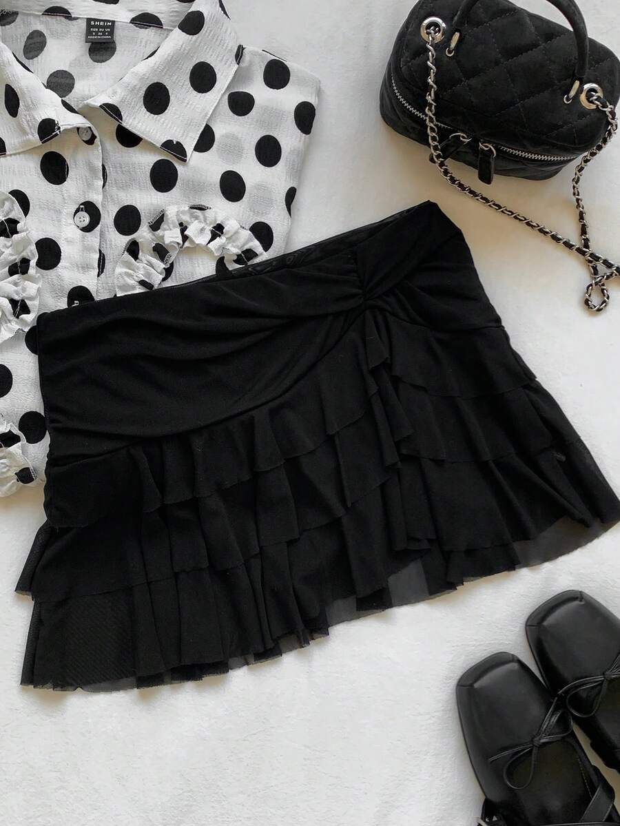 Black tiered ruffle mini cake skirt for women featuring a mid-waist pleated design and layered ruffle hem.