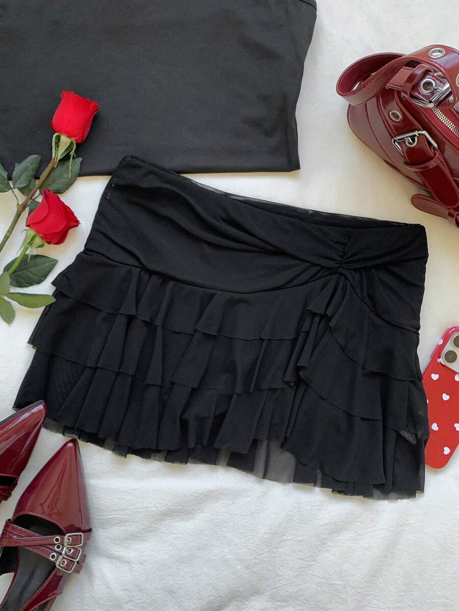 Black tiered ruffle mini cake skirt for women featuring a mid-waist pleated design and layered ruffle hem.