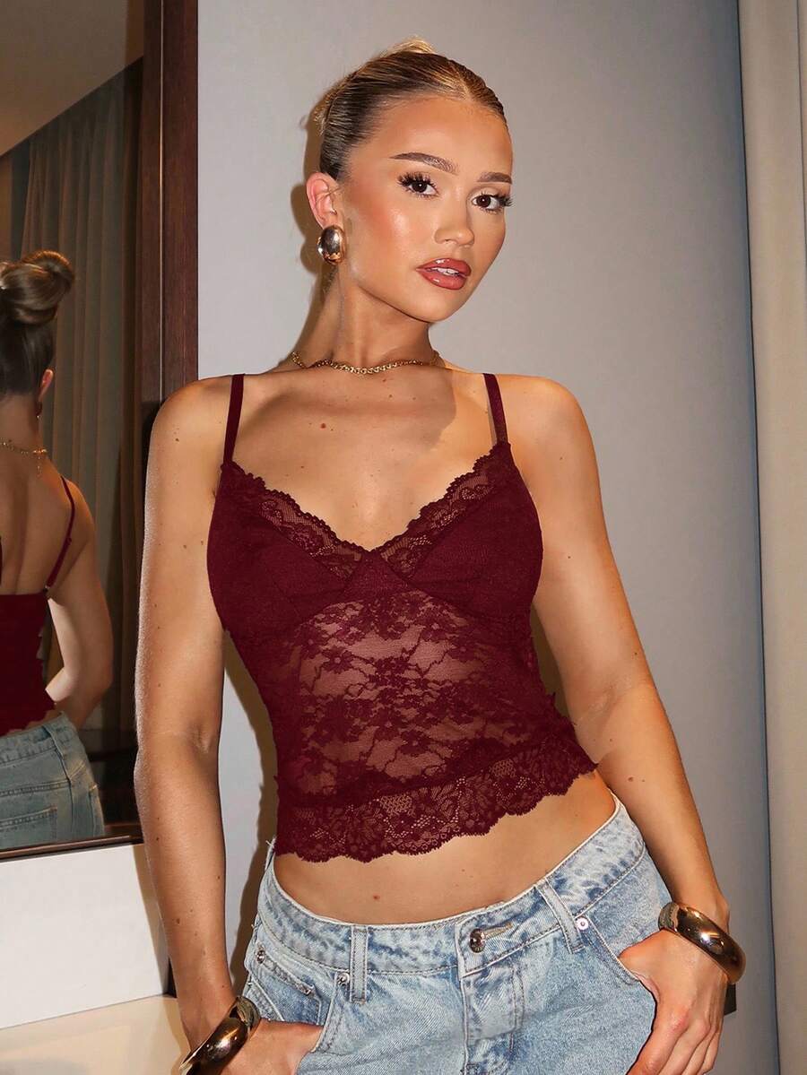 Black floral lace cropped camisole top for women featuring delicate spaghetti straps, cup detail, and semi-sheer contrast lace.