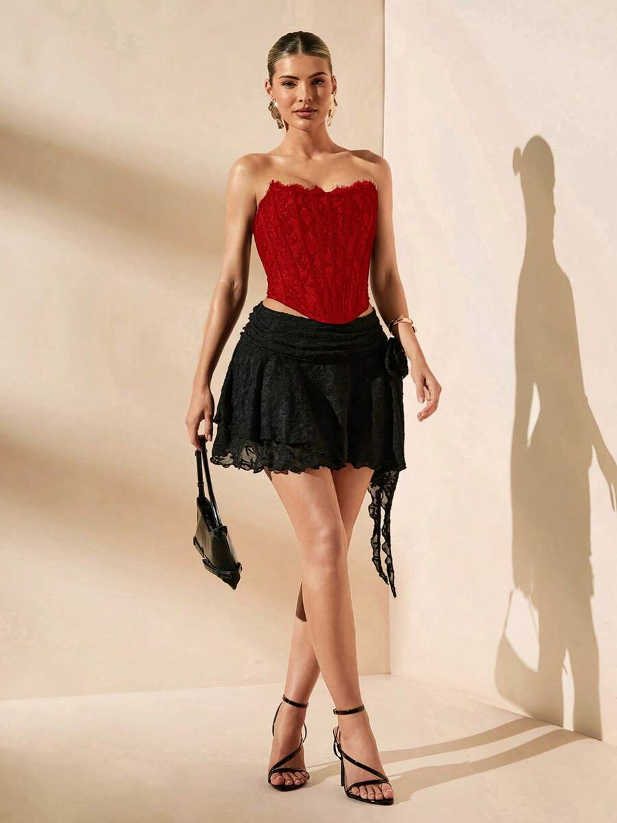 Women's strapless bustier crop top with contrast lace, lace-up detail, and an asymmetric hem in a slim-fit satin finish.