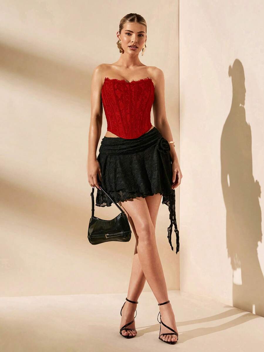Women's strapless bustier crop top with contrast lace, lace-up detail, and an asymmetric hem in a slim-fit satin finish.