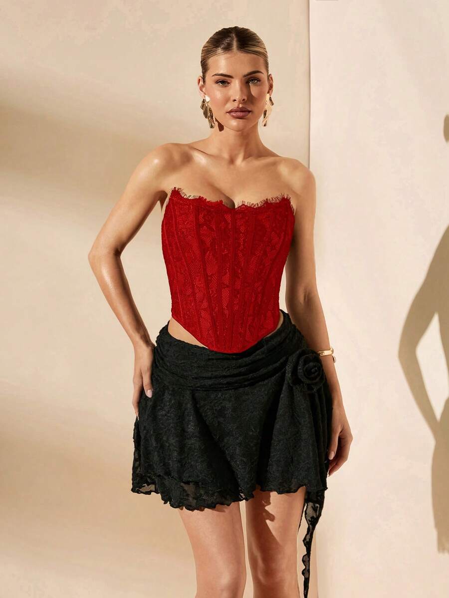 Women's strapless bustier crop top with contrast lace, lace-up detail, and an asymmetric hem in a slim-fit satin finish.