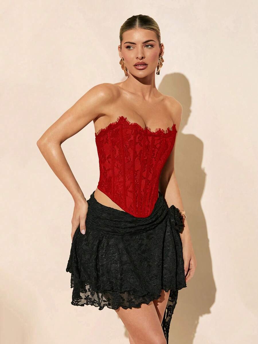 Women's strapless bustier crop top with contrast lace, lace-up detail, and an asymmetric hem in a slim-fit satin finish.