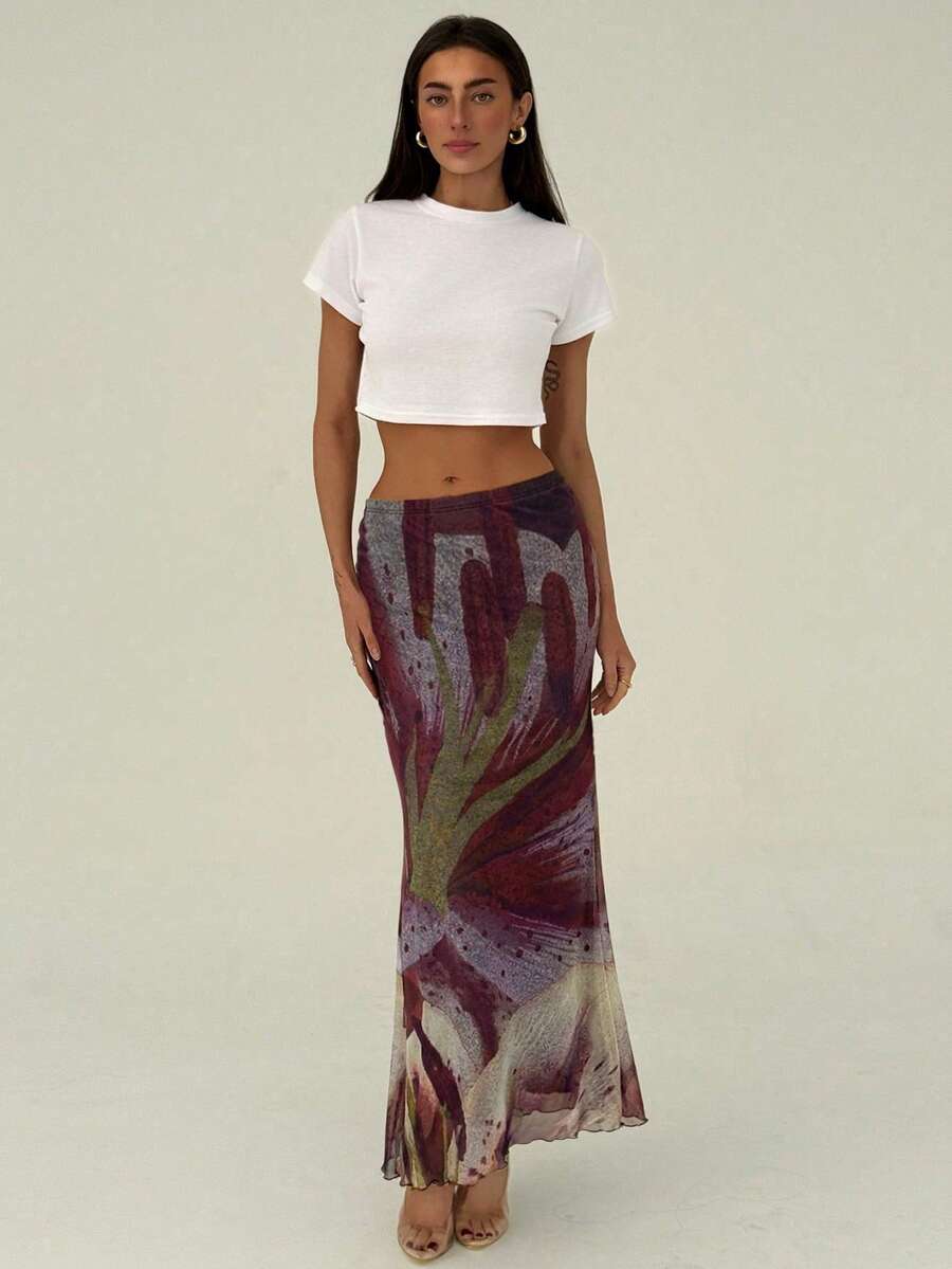Black floral print mesh maxi skirt for women featuring high waist, ruched asymmetrical design, lettuce trim, and mermaid hem.