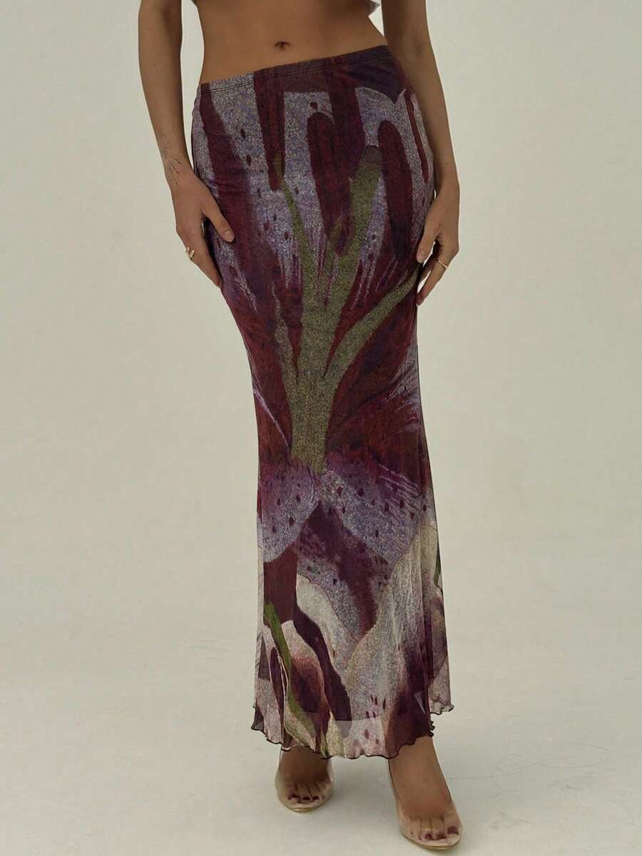 Black floral print mesh maxi skirt for women featuring high waist, ruched asymmetrical design, lettuce trim, and mermaid hem.