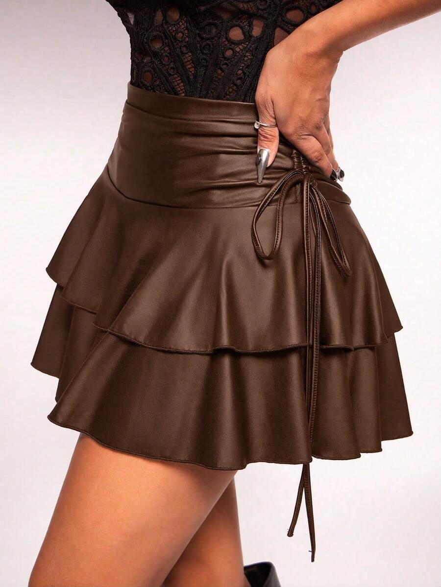 Women's black PU coated layered ruffle mini skirt featuring a high waist, tiered ruffle hem, and zipper detail.