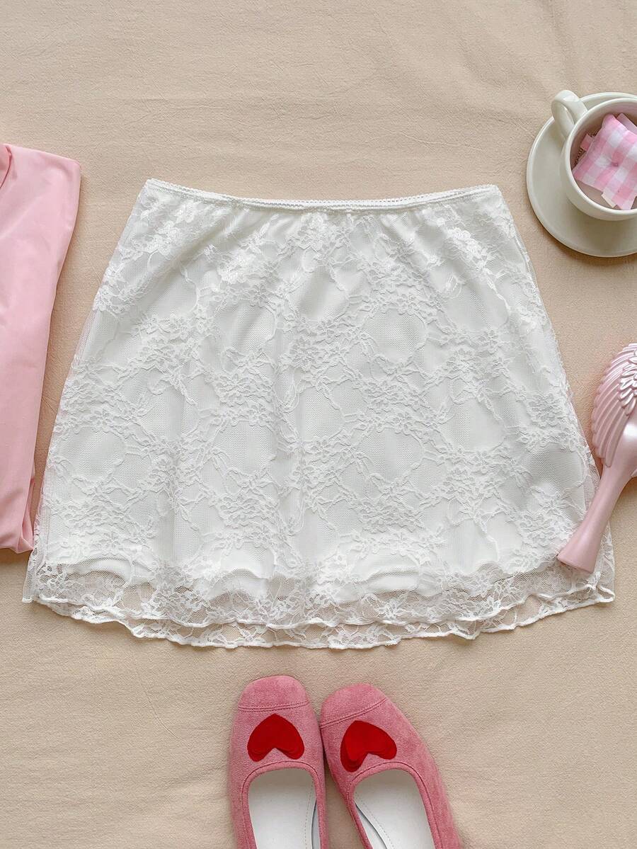Women's black contrast lace mini skirt with low waist design, embroidery, and contrast mesh details.