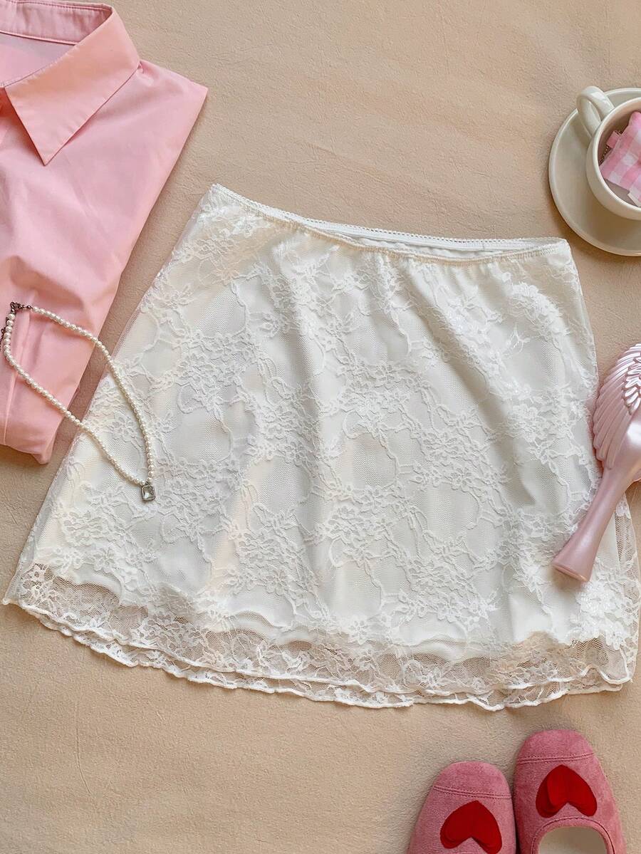 Women's black contrast lace mini skirt with low waist design, embroidery, and contrast mesh details.