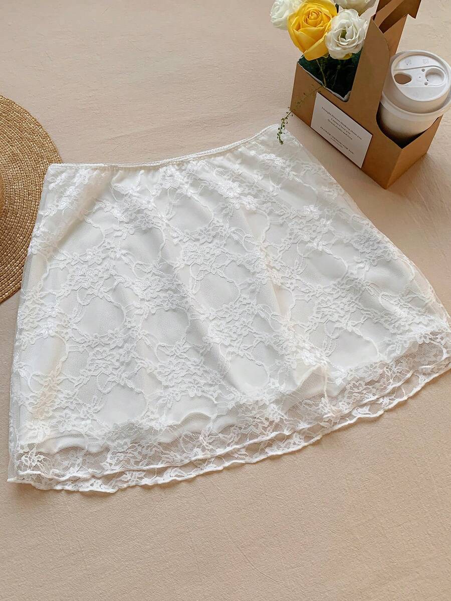 Women's black contrast lace mini skirt with low waist design, embroidery, and contrast mesh details.