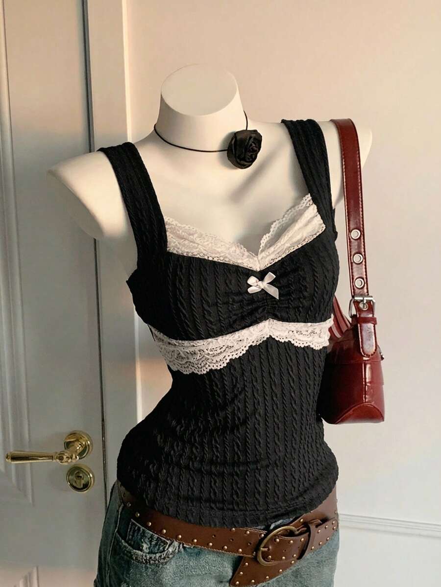 Black and white polka dot knit camisole tank top featuring delicate contrast lace trim, a cute bow accent at the sweetheart neckline, and slender shoulder straps.