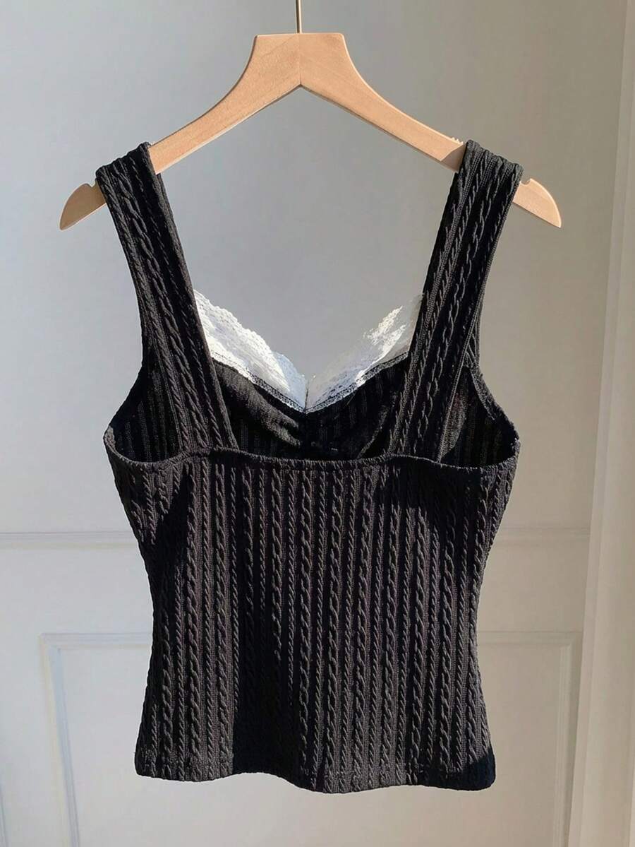 Black and white polka dot knit camisole tank top featuring delicate contrast lace trim, a cute bow accent at the sweetheart neckline, and slender shoulder straps.