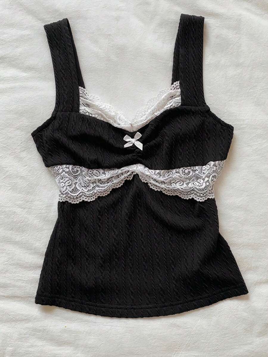 Black and white polka dot knit camisole tank top featuring delicate contrast lace trim, a cute bow accent at the sweetheart neckline, and slender shoulder straps.