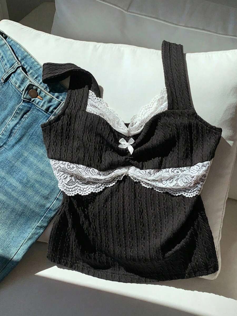 Black and white polka dot knit camisole tank top featuring delicate contrast lace trim, a cute bow accent at the sweetheart neckline, and slender shoulder straps.