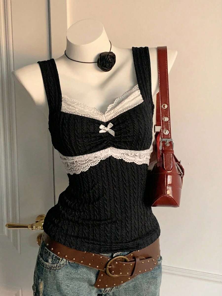 Black and white polka dot knit camisole tank top featuring delicate contrast lace trim, a cute bow accent at the sweetheart neckline, and slender shoulder straps.