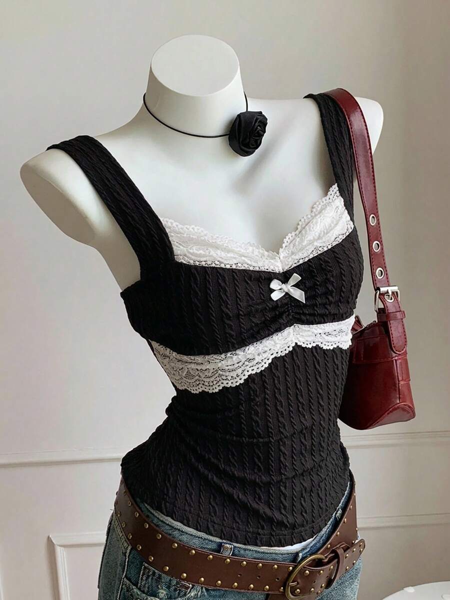 Black and white polka dot knit camisole tank top featuring delicate contrast lace trim, a cute bow accent at the sweetheart neckline, and slender shoulder straps.