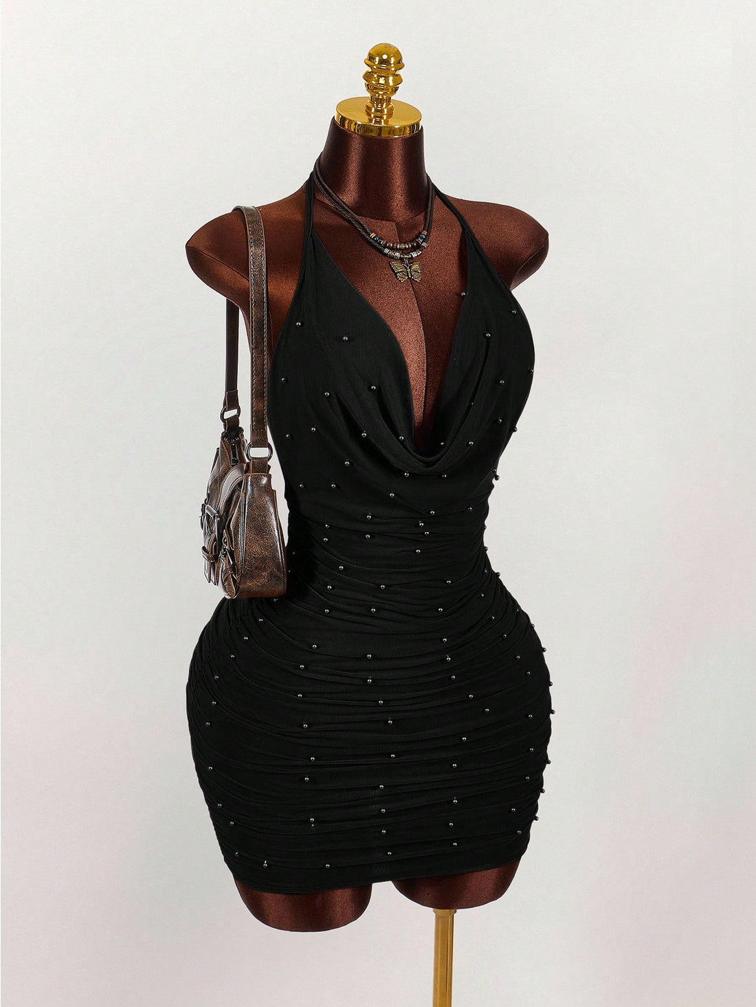 Women's black halter mini dress featuring a backless draped design, semi-sheer mesh fabric, and slim pencil fit.