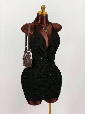 Women's black halter mini dress featuring a backless draped design, semi-sheer mesh fabric, and slim pencil fit.