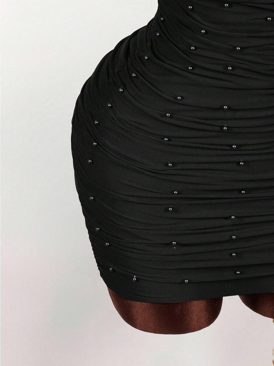 Women's black halter mini dress featuring a backless draped design, semi-sheer mesh fabric, and slim pencil fit.