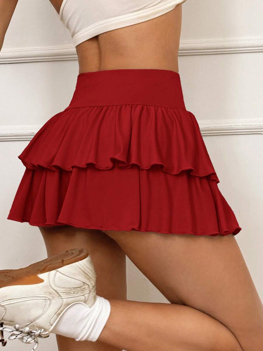 Black low waist knit mini skirt featuring a tiered ruffle hem and skinny high stretch fit.