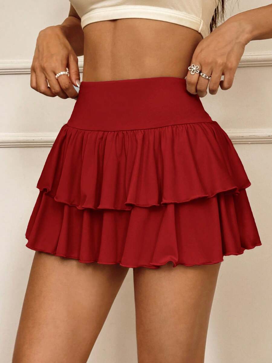 Black low waist knit mini skirt featuring a tiered ruffle hem and skinny high stretch fit.